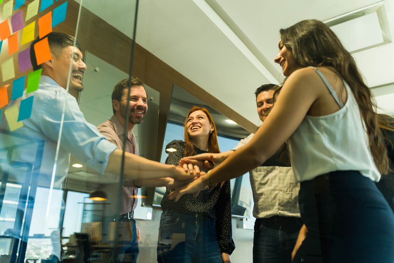A collaborative team gathered around a workspace, clearly demonstrating mutual trust and engagement. This article explores four key trust building behaviours that set high-performing teams apart, providing leaders with practical guidance to strengthen team dynamics, encourage accountability, and create lasting alignment.